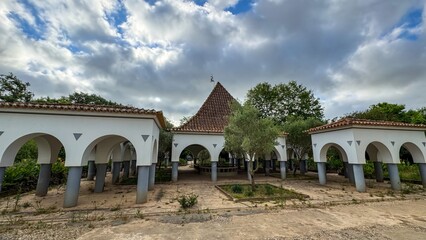 White arched sanctuary under brooding skies evokes architectural nostalgia, perfect for Andalusian...