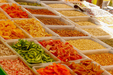 candied fruits, nuts, dried fruits in trays for sale at a farmers market