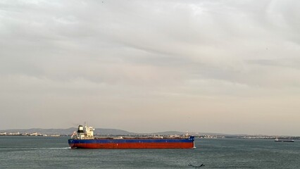 Vast cargo ship glides through ethereal seascape, evoking maritime Wanderlust and Global Shipping...