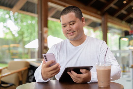 Asian plus size happy man sitting in cafe restaurant