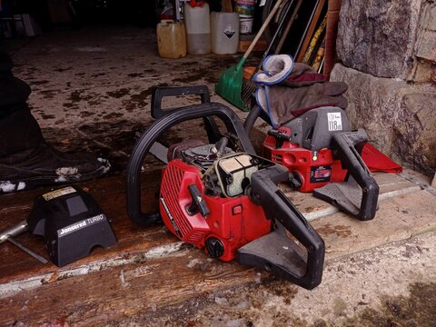 Close up of two chainsaws, one of which has been opened.