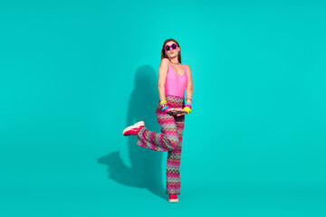 Young woman in vibrant retro fashion posing stylishly on teal background with bold accessories and...