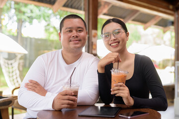 Happy young couple sitting in coffee shop