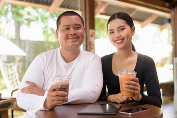Happy young couple sitting in coffee shop
