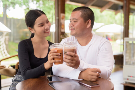 Happy young couple sitting in coffee shop