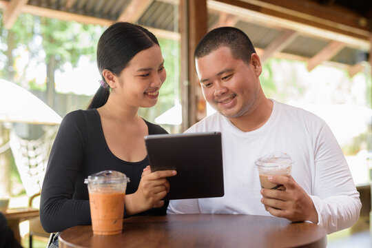 Happy young couple sitting in coffee shop