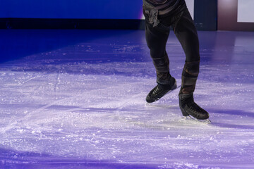 Detail of the Legs and Ice Skates of a Skater Executing his Artistic and Technical Performance on the Ice Rink