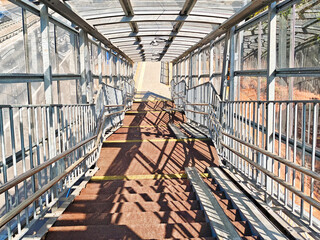 View from a pedestrian ramp descending towards a busy street during a sunny day