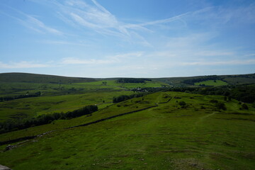 Beautiful view of rolling green hills under blue sky at Solomon’s Temple, Buxton, England.