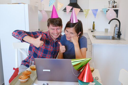 Young family video chatting with relatives on a laptop during a birthday celebration. Smiling and joyful, they connect with loved ones, sharing a special occasion from the comfort of their home.