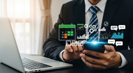 Fototapeta premium Businessman uses smartphone with calendar and data analysis near laptop