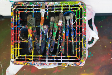 Konzept Kunst, Malen und Farbe: Authentisch mit Farbe bedeckte Pinsel auf einem farbverschmierten...