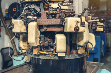 Side view of knitting machine with cotton yarn in sock factory. Knitting machine with dust from yarn. Industrial background.
