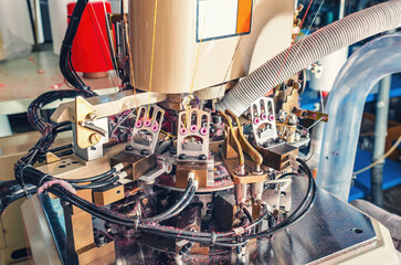 Close-up photo of machine in workshop with exhaust pipe on industrial knitting machine. Knitting factory mechanisms.