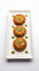 Aloo tikki recipe indian snack potato patties served with green chutney on a white plate delicious food