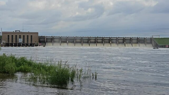 Panning left to right of hydroelectricity dam on Wisconsin river with all spillways partiality opened after heavy rains