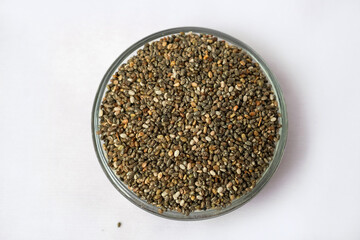 Chia seeds in galss bowl ,isolated on white background. The concept of Healthy superfood. Closeup macro of small organic chia seeds. Top view.