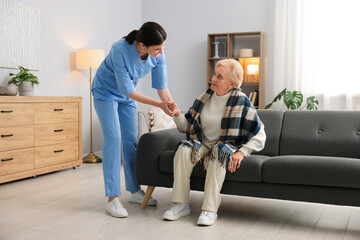 Nurse assisting senior woman indoors. Home health care service