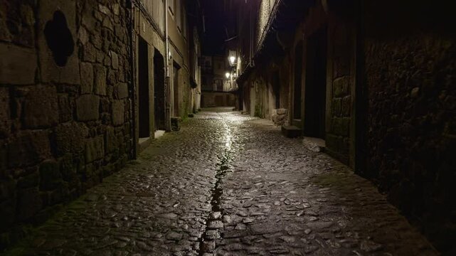 Empty night street in La Alberca with stone walls and lantern light. Ideal for moody travel, history, or European village atmosphere.