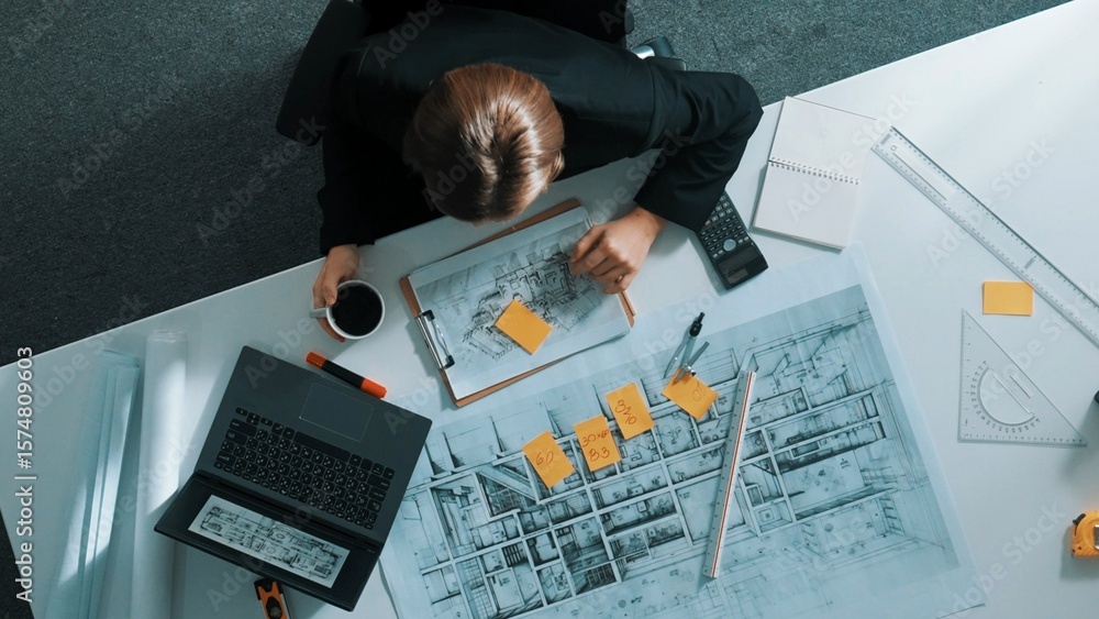 Poster top down view civil engineer writing sticky note and looking at laptop. aerial view architect sittin