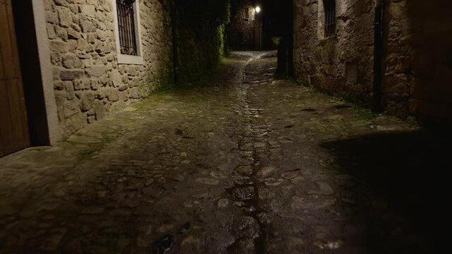 Empty night street in La Alberca with stone walls and lantern light. Ideal for moody travel, history, or European village atmosphere.