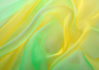 Obraz premium Elegant blending of yellow and green silk fabric creates a dreamy abstract background