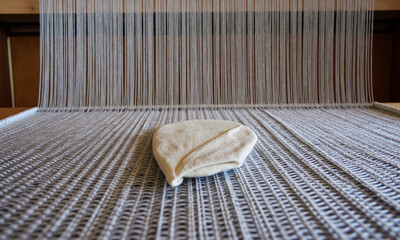 A Piece of Silk Fabric Being Woven on a Traditional Loom, with an Ultra-Sharp Focus on the Shuttle Passing Between the Taut Threads of the Warp