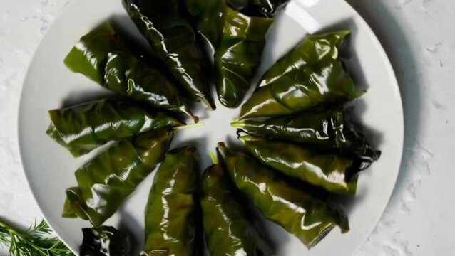 Top view of delicious leaf dolma inside plate on white surface
