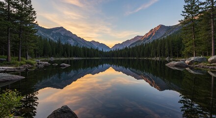 Mountain lake reflects forestclad peaks at sunset