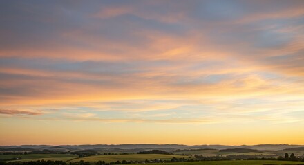 Obraz premium A hazy, beautiful sunset over rolling hills