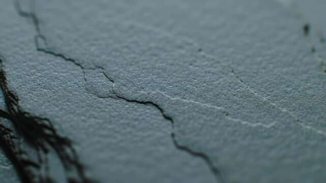 Extreme close-up of textured slate rock with black fibers on surface