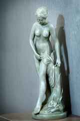 Plaster statue of a young woman on a pedestal is used as an interior element in a living space.
