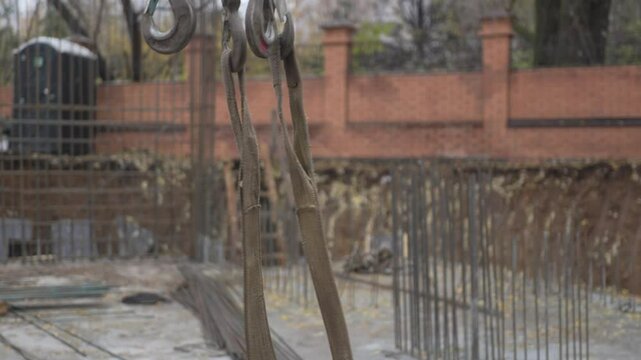 Worker hand in glove waves prohibiting hoist lifting at construction site closeup. Transporting heavy items with powerful machinery in city
