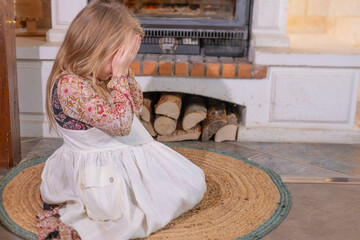 Little girl in folk dress crying with hands on face, Crying sensitive child, expressing deep...