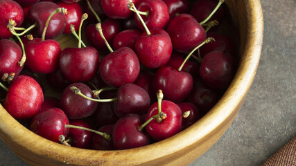 juicy, richly colored cherries in a wooden bowl