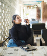 Young business woman manager asian one person sit on sofa smile cheerful hand holding tablet and smartphone talk happiness about work new project job online product sale marketing in cafe coffee shop