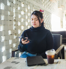 Young business woman manager asian one person sit on sofa smile cheerful hand holding tablet and smartphone talk happiness about work new project job online product sale marketing in cafe coffee shop