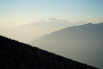 Serene Mountain Landscape with Hazy Peaks Under a Clear Blue Sky