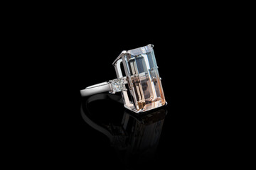ring made of white metal, silver, gold with a stone topaz polychrome and diamonds on a black...