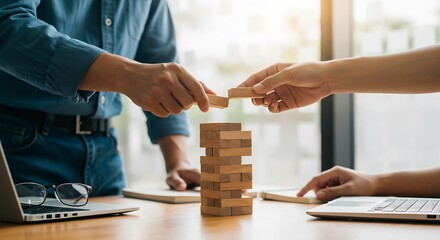 Collaborative Teamwork: Businesspeople Strategically Building a Wooden Block Tower, Representing Growth, Planning, and Risk Management