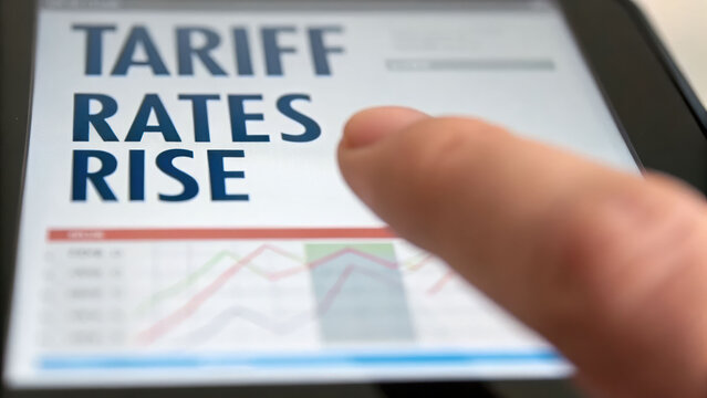 Tariff rate and import costs rise shown on digital device with finger pointing to screen indicating economic impact and financial concern