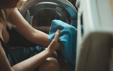 Woman loading laundry into a washing machine.