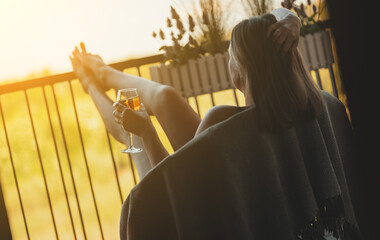 Woman enjoying her rose wine on balcony.