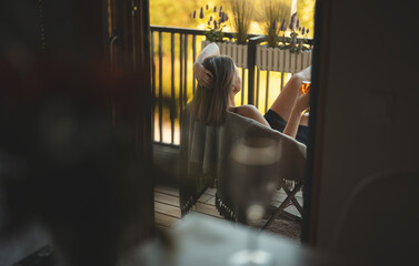 Woman enjoying her rose wine on balcony.