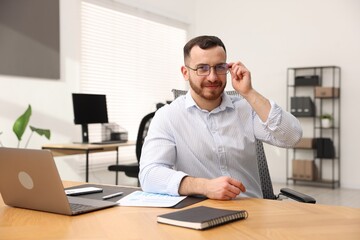 Fototapeta premium Handsome man working at desk in office