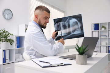 Doctor with lung MRI scan having online consultation via laptop in clinic
