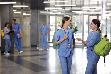 Medical students in uniforms indoors, selective focus