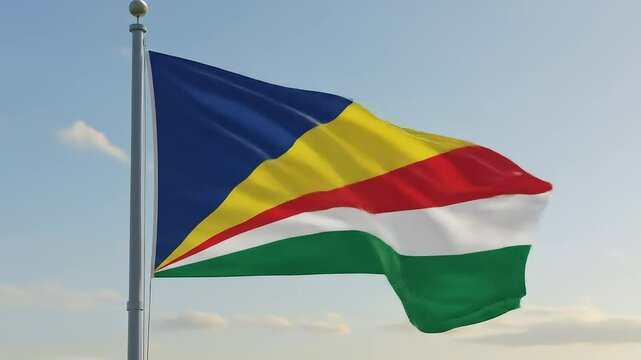 The Seychellois flag fluttering calmly in the early morning breeze, centered against a soft, clear sky.