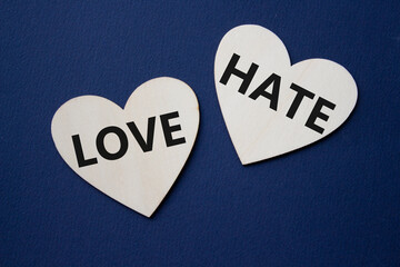 Love vs Hate symbol. Concept word Love vs Hate on wooden hearts. Beautiful deep blue background....