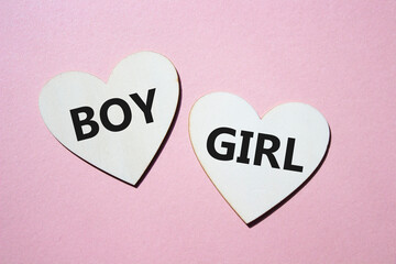 Boy or Girl symbol. Concept word Boy or Girl on wooden hearts. Beautiful pink background. Gender and Boy or Girl concept. Copy space